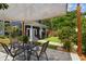 Backyard patio area featuring a dining table, shade, manicured landscaping, and a lush lawn at 2807 N Morgan St, Tampa, FL 33602
