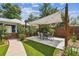 Landscaped backyard area featuring a dining table, shade canopy, and artificial turf for easy maintenance at 2807 N Morgan St, Tampa, FL 33602