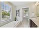 Bright bathroom with a soaking tub under a window and a vanity with dark wood cabinets at 2807 N Morgan St, Tampa, FL 33602