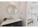 Bathroom featuring vanity with gold fixtures, round mirror, and a bench by the window at 2807 N Morgan St, Tampa, FL 33602