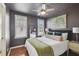 Stylish bedroom with dark walls, wood floors, large bed, and lots of natural light at 2807 N Morgan St, Tampa, FL 33602