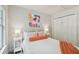 Comfortable bedroom featuring a queen bed, wood floors, a colorful piece of art, and closet at 2807 N Morgan St, Tampa, FL 33602