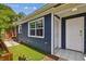 Exterior view of the home showcasing the entrance, updated siding, and a well-maintained artificial turf side yard at 2807 N Morgan St, Tampa, FL 33602