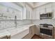 Modern kitchen boasts stainless steel appliances, white cabinets, subway tile backsplash, and farmhouse sink at 2807 N Morgan St, Tampa, FL 33602