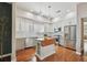 Bright, modern kitchen featuring stainless steel appliances, a farmhouse sink, white cabinets and hardwood floors at 2807 N Morgan St, Tampa, FL 33602
