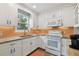 Well-lit kitchen with white cabinets, granite counters, and stainless steel appliances offering a functional layout at 2807 N Morgan St, Tampa, FL 33602
