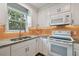 Bright kitchen showcasing modern appliances, white cabinets, granite counters, and an inviting window view at 2807 N Morgan St, Tampa, FL 33602