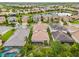 Aerial view of the neighborhood showcasing lake, meticulously landscaped yards, and tile roofs, offering a picturesque setting at 30900 Spruceberry Ct, Wesley Chapel, FL 33543