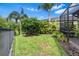 Well-maintained backyard featuring lush grass, tropical landscaping, and a screened-in patio, perfect for outdoor enjoyment at 30900 Spruceberry Ct, Wesley Chapel, FL 33543
