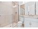Bathroom featuring a tiled shower with glass door, toilet, and single sink vanity at 30900 Spruceberry Ct, Wesley Chapel, FL 33543