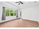 Bright bedroom featuring wood floors, a large window, and tray ceilings at 30900 Spruceberry Ct, Wesley Chapel, FL 33543