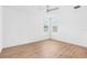 Bright, white bedroom with wood-look floors, ceiling fan, and two windows at 30900 Spruceberry Ct, Wesley Chapel, FL 33543
