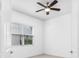 Bright bedroom featuring a ceiling fan, neutral carpet, window and white walls at 30900 Spruceberry Ct, Wesley Chapel, FL 33543