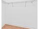 Bright walk-in closet showcasing white walls, light wood flooring, and minimal wire shelving at 30900 Spruceberry Ct, Wesley Chapel, FL 33543