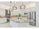 Bright modern kitchen with granite counters, stainless steel appliances, and decorative pendant lighting at 30900 Spruceberry Ct, Wesley Chapel, FL 33543