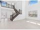 Open concept living area with high ceilings, tile flooring, and staircase with black wrought iron railings at 30900 Spruceberry Ct, Wesley Chapel, FL 33543