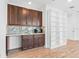 Modern mini-bar featuring granite countertop, wooden cabinets, and built-in shelving at 30900 Spruceberry Ct, Wesley Chapel, FL 33543