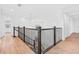 Bright, open staircase with wood floors and dark wood railing leads to the upper level of this modern home at 30900 Spruceberry Ct, Wesley Chapel, FL 33543