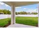 The covered patio provides a serene view of the well-maintained lawn and fenced yard at 3108 W Ballast Point Blvd, Tampa, FL 33611