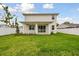 Spacious backyard with a lush green lawn and a covered patio, perfect for outdoor entertaining at 3108 W Ballast Point Blvd, Tampa, FL 33611