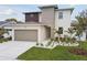 Modern two-story home featuring a two-car garage and a well-manicured lawn at 3108 W Ballast Point Blvd, Tampa, FL 33611
