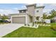 Contemporary home featuring a two-car garage, modern design, and landscaped front yard at 3108 W Ballast Point Blvd, Tampa, FL 33611