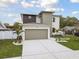 View of a modern house with a two-car garage, stylish exterior, and a manicured lawn at 3108 W Ballast Point Blvd, Tampa, FL 33611