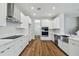 A contemporary kitchen boasts stainless steel appliances, white cabinets, and wood flooring at 3108 W Ballast Point Blvd, Tampa, FL 33611