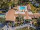 Aerial view of the community clubhouse, pool and hot tub, with mature landscaping at 3143 Mission Grove Dr, Palm Harbor, FL 34684