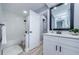 This bathroom has a white vanity with a modern sink, a large mirror, and a shower at 3143 Mission Grove Dr, Palm Harbor, FL 34684