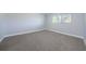 An empty bedroom showcasing a window and neutral carpeting at 3143 Mission Grove Dr, Palm Harbor, FL 34684