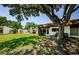 Charming home exterior with a lush front lawn and mature shade tree at 3143 Mission Grove Dr, Palm Harbor, FL 34684