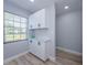 A bright eat in kitchen with white cabinets and wood look flooring at 3143 Mission Grove Dr, Palm Harbor, FL 34684