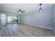 Open-concept living room featuring new floors and light filled sunroom, perfect for relaxation and entertaining at 3143 Mission Grove Dr, Palm Harbor, FL 34684