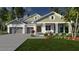 Inviting two-story home with a covered front porch, lush landscaping, and an attached two-car garage at 3207 Lake Padgett Dr, Land O Lakes, FL 34639