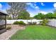 This beautiful backyard offers privacy with a white fence, mature trees and plantings, and a stone sitting area at 37438 Picketts Mill Ave, Zephyrhills, FL 33542