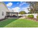 Well-manicured backyard featuring a screened-in lanai, stone patio area, and lush green lawn at 37438 Picketts Mill Ave, Zephyrhills, FL 33542