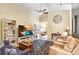 Spacious living room with vaulted ceilings, fan, and a large television for entertaining at 37438 Picketts Mill Ave, Zephyrhills, FL 33542