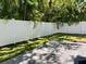 A fenced backyard features a stone patio, grassy lawn, and lush tropical landscaping creating a private outdoor space at 410 S Church Ave, Tampa, FL 33609