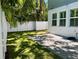 A fenced backyard features a stone patio, grassy lawn, and lush tropical landscaping creating a private outdoor space at 410 S Church Ave, Tampa, FL 33609