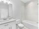 Bright bathroom featuring a tub with tiled shower, vanity with modern fixtures, and white toilet at 410 S Church Ave, Tampa, FL 33609