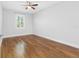 Bedroom with hardwood floors, ceiling fan, and a window for natural light at 410 S Church Ave, Tampa, FL 33609