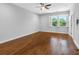 Neutral bedroom featuring a ceiling fan, window with shutters, and hardwood flooring at 410 S Church Ave, Tampa, FL 33609