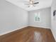 Bright bedroom featuring hardwood floors, ceiling fan, and a window with plantation shutters at 410 S Church Ave, Tampa, FL 33609