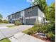 Newly constructed townhomes featuring gray and white exterior, private garages, and paver driveways at 410 S Church Ave, Tampa, FL 33609