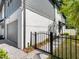 Side view of a gray and white two-story home with brick driveway and a black iron gate at 410 S Church Ave, Tampa, FL 33609
