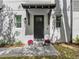 Close up on charming covered home entrance with brick pathway and manicured landscaping at 410 S Church Ave, Tampa, FL 33609