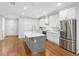 Modern kitchen with an island, white cabinets, new stainless steel appliances, and hardwood floors at 410 S Church Ave, Tampa, FL 33609