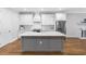 Modern kitchen with a white countertops, a gray island, new appliances, and hardwood floors at 410 S Church Ave, Tampa, FL 33609