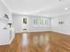 Spacious living room featuring wood floors, light gray walls, built-in bar, and three windows at 410 S Church Ave, Tampa, FL 33609